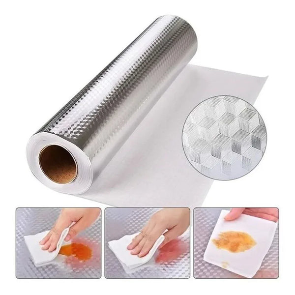 Roll of self-adhesive aluminum foil stove shield and splash guard being applied to a surface.