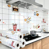 Rolls of self-adhesive marble contact paper displayed on a kitchen backsplash with a stainless steel hood.