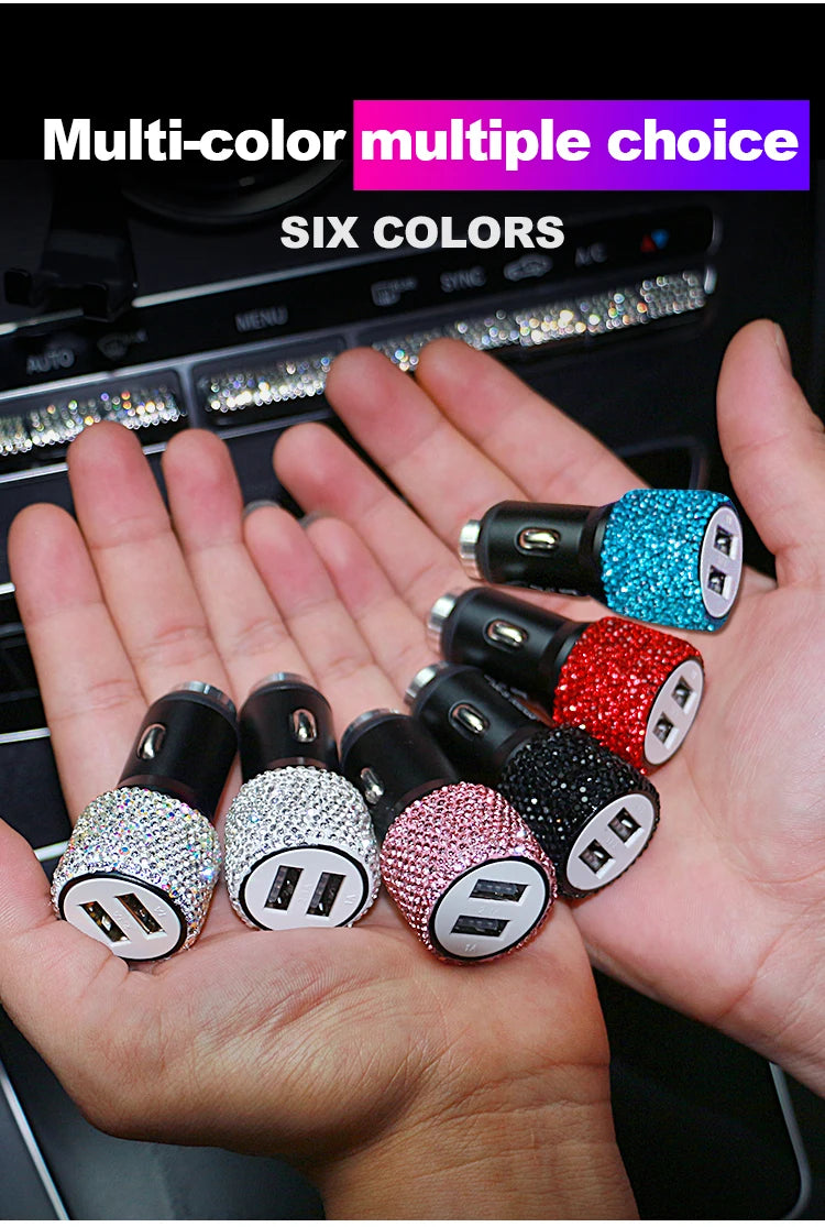 A hand holds six multi-color rhinestone USB car chargers with various colors and designs.