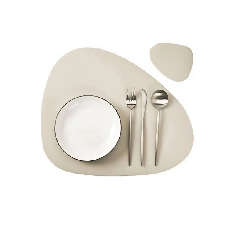 A set of neutral-toned reversible non-slip placemats with a white plate, fork, and spoon.