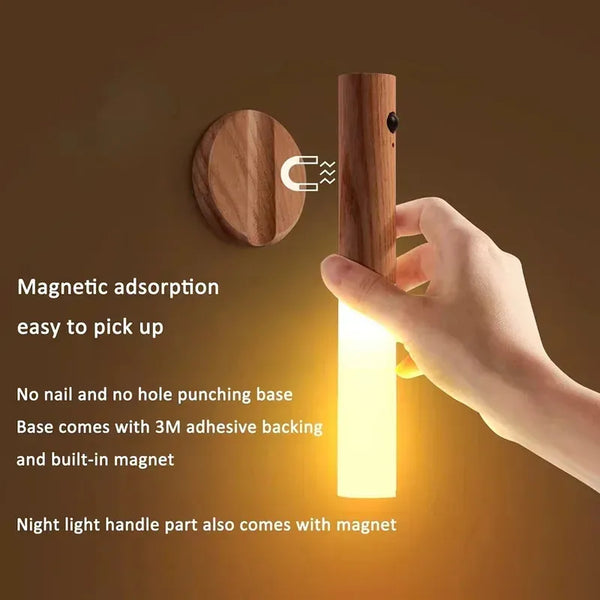 Una mano sostiene una lámpara de noche magnética de madera con luz blanca brillante.