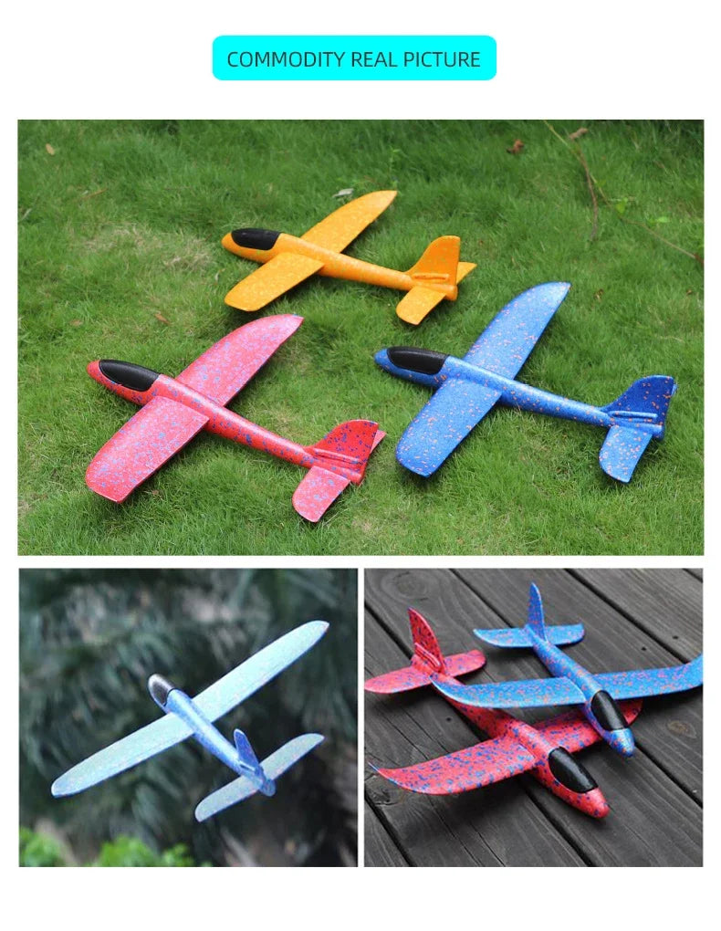 Four foam glider planes in yellow, red, and blue colors resting on green grass.