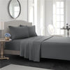 A gray bedding set featuring a fitted sheet, flat sheet, and pillowcases on a bed in a bright room.