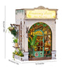 A miniature DIY book nook kit featuring a detailed brick facade with an arched window and greenery.