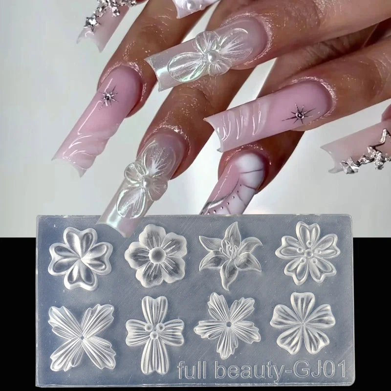 A hand displays a manicure with sheer pink and white floral silicone nail art molded designs.
