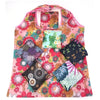 A pink floral shopping tote with a clear window and several patterned fabric pouches.