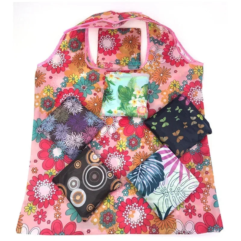 A pink floral shopping tote with a clear window and several patterned fabric pouches.