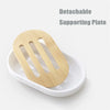 A wooden detachable supporting plate for a soap dispenser is shown resting in a white dish.