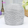 A ball of silver metallic silk crochet yarn used for knitting and macrame.