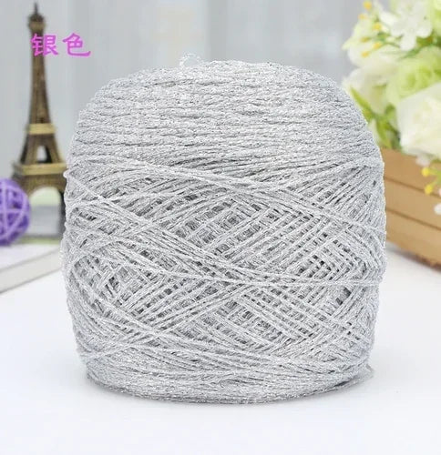 A ball of silver metallic silk crochet yarn used for knitting and macrame.