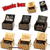 A collection of vintage hand-crank wooden music boxes featuring themes like The Godfather, Queen, and Pink Panther.