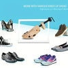 Adjustable wooden shoe stretcher tool shown next to various types of shoes including heels and casual footwear.