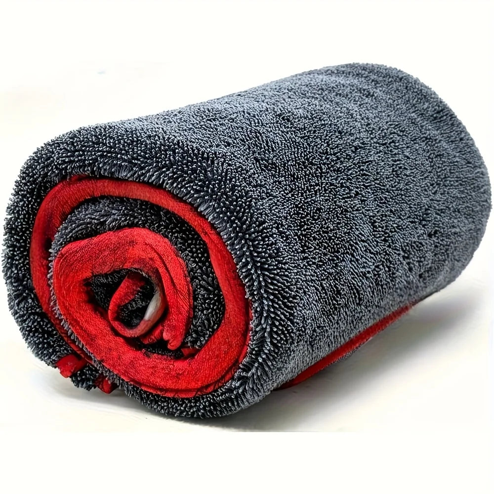 A rolled gray microfiber drying towel with a red accent, showing its texture and absorbent material.