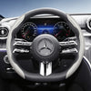 Close-up view of a black steering wheel with carbon fiber texture covers and modern instrument cluster details.