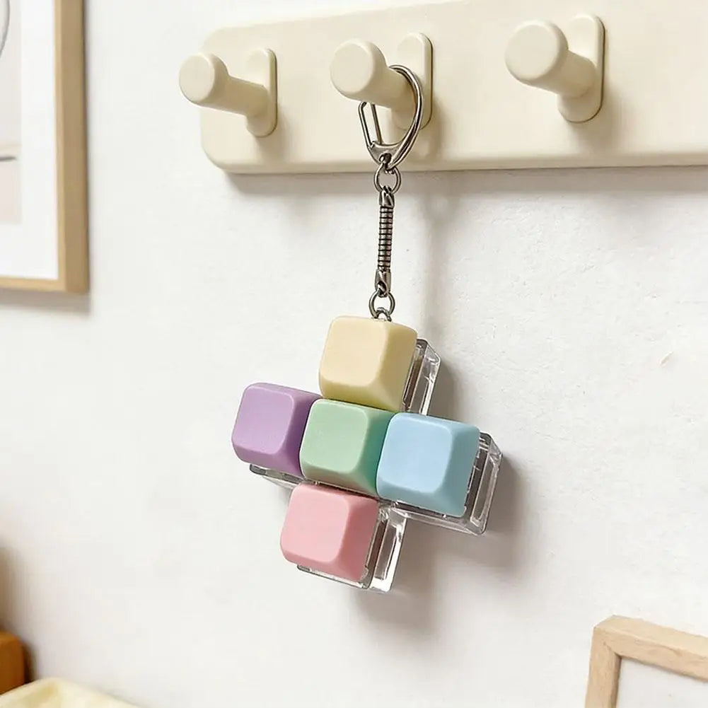 A keychain featuring five colorful, translucent mechanical keyboard fidget cubes hanging from a silver chain.