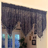 Black gothic lace curtain valance with irregular window pendants hanging in a bright room.