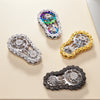 A collection of four iridescent and metallic fidget spinners made from zinc alloy in various colors and finishes.