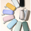 A variety of colorful, round-shaped umbrella bags and capsule cases are displayed on a light background.