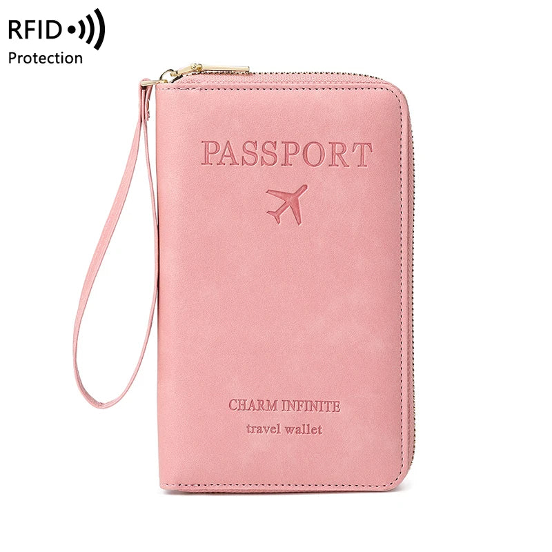 A pink passport wallet with a strap, featuring the text 'PASSPORT' and 'CHARM INFINITE travel wallet'.