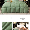 Mint green luxury goose and duck down comforter with a cotton cover displayed on a bed.