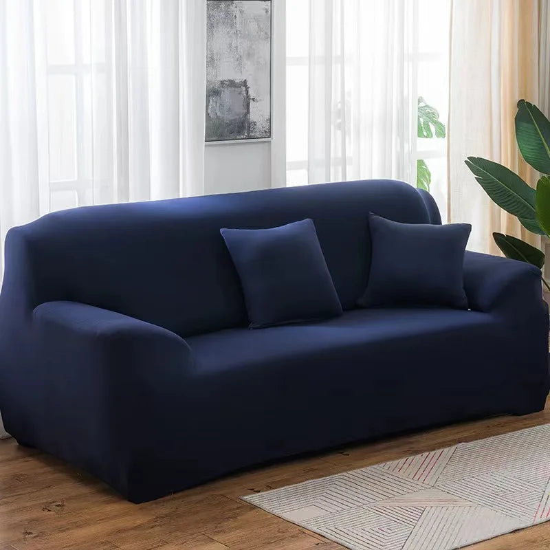 A dark navy blue elastic stretch sofa cover for a 3-seater sofa placed in a bright living room.