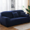 A dark navy blue elastic stretch sofa cover for a 3-seater sofa placed in a bright living room.