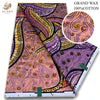 A close-up view of a pink glitter African wax print fabric featuring purple, orange, and yellow swirling patterns.