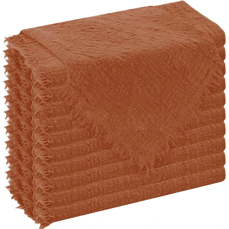 A stack of six raw-edge polyester cloth napkins in a rust orange color.