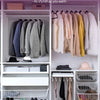 Elegant closet featuring various clothing items and velvet non-slip hangers in a white storage system.