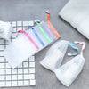 A set of foaming mesh bath poufs in various colors with hanging loops displayed on a grid background.