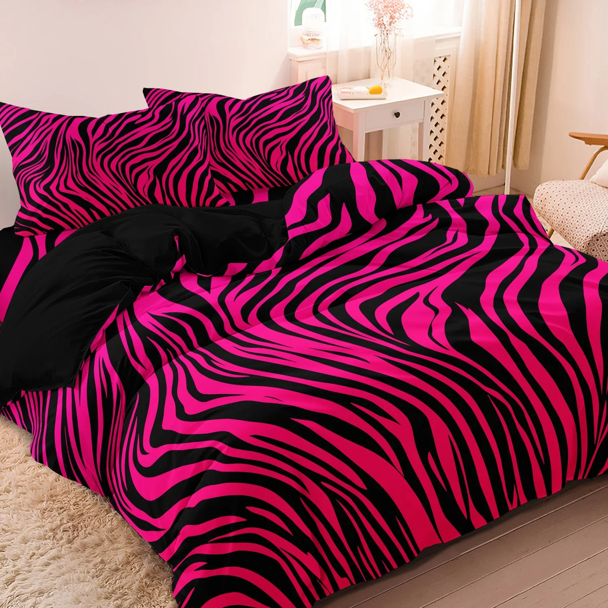 A vibrant pink and black zebra print duvet cover set displayed on a bed.