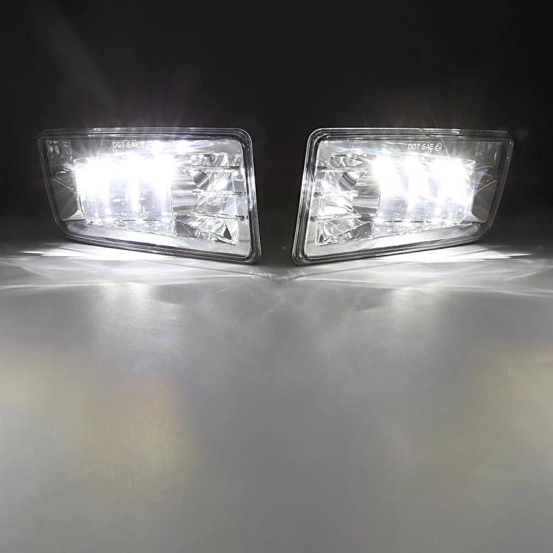 A pair of clear LED fog light assemblies mounted on a vehicle, shining bright light onto a surface.