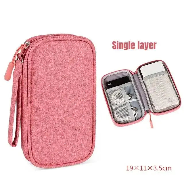 A pink single layer travel organizer pouch for cables and accessories with a zipper and strap.