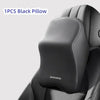 A single black memory foam car headrest pillow with shoulder support placed on a dark gray car seat.