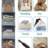 Over-the-door hanging organizer with clear compartments holding a handbag, toy, towel, towel, towel, socks, umbrella, and clo