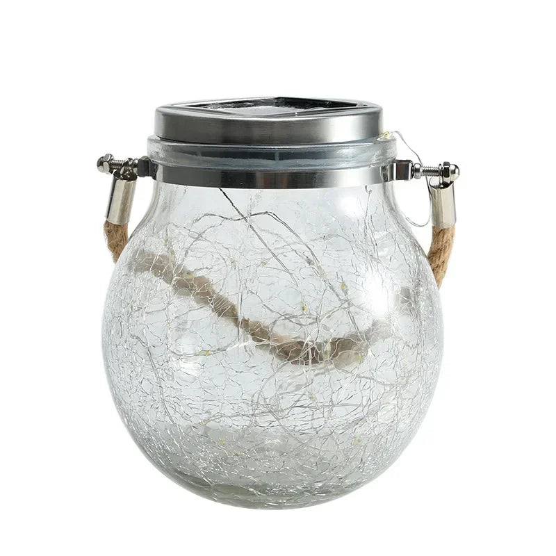 A clear crackle glass solar lantern with a metal top and wooden handles, emitting a warm ambient glow.