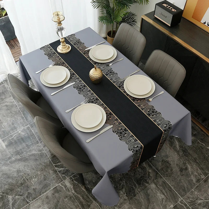 A gray tablecloth set for a formal meal featuring black and silver geometric patterns on a dining table.