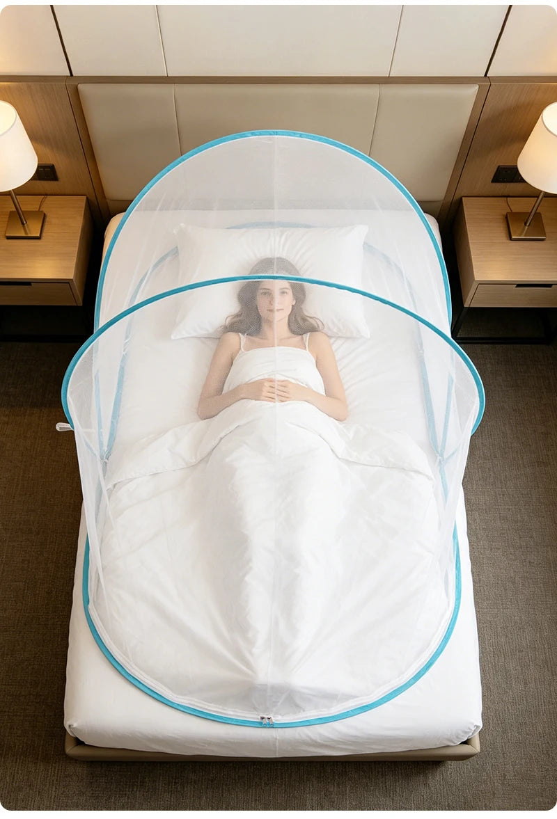 A white bed with a mosquito net draped over it, featuring a blue trim and a person lying in the center.