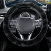 Close-up view of a black winter plush steering wheel cover on a car's interior.