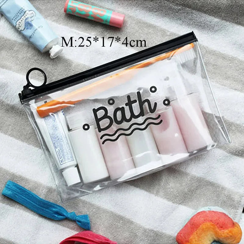 A clear plastic toiletry bag filled with various white and pink bath products, resting on a striped cloth.