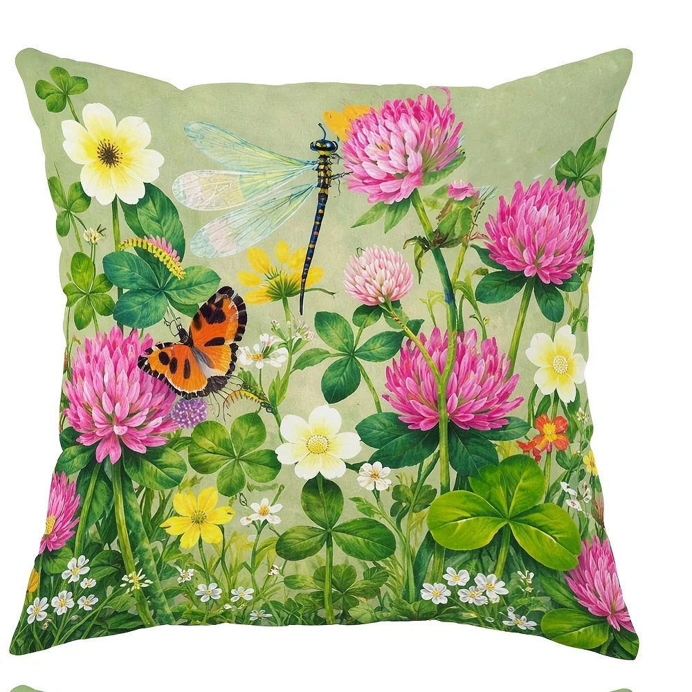 A floral fabric pillow featuring pink and yellow wildflowers, green leaves, and a dragonfly.