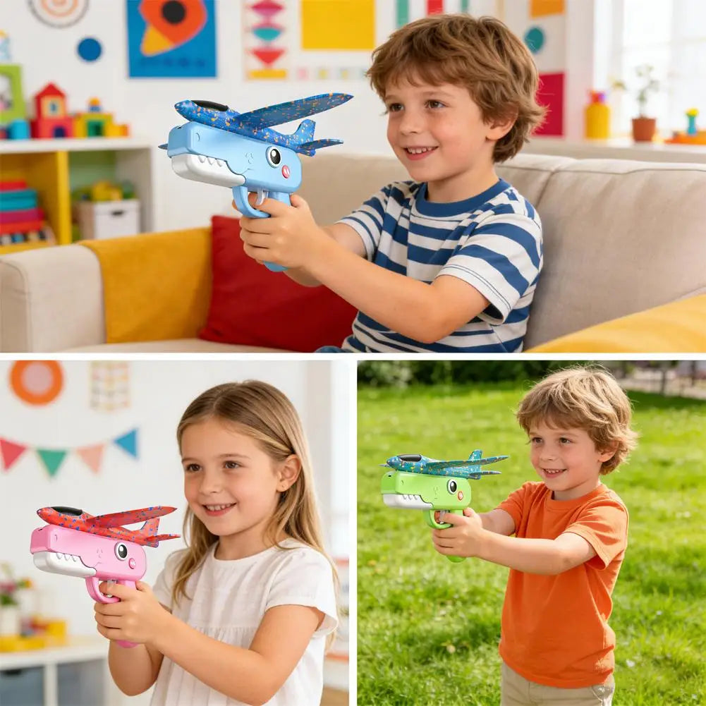 A young boy holds a foam catapult airplane toy in a grassy outdoor setting.