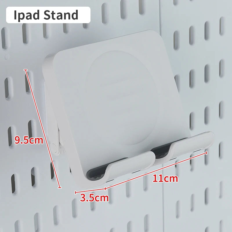A white iPad stand is mounted on a pegboard organizer with hooks and shelves.