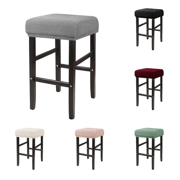 A set of four bar stools with gray, maroon, and green fabric slipcovers.