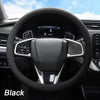 Black soft silicone steering wheel cover installed in a car interior.