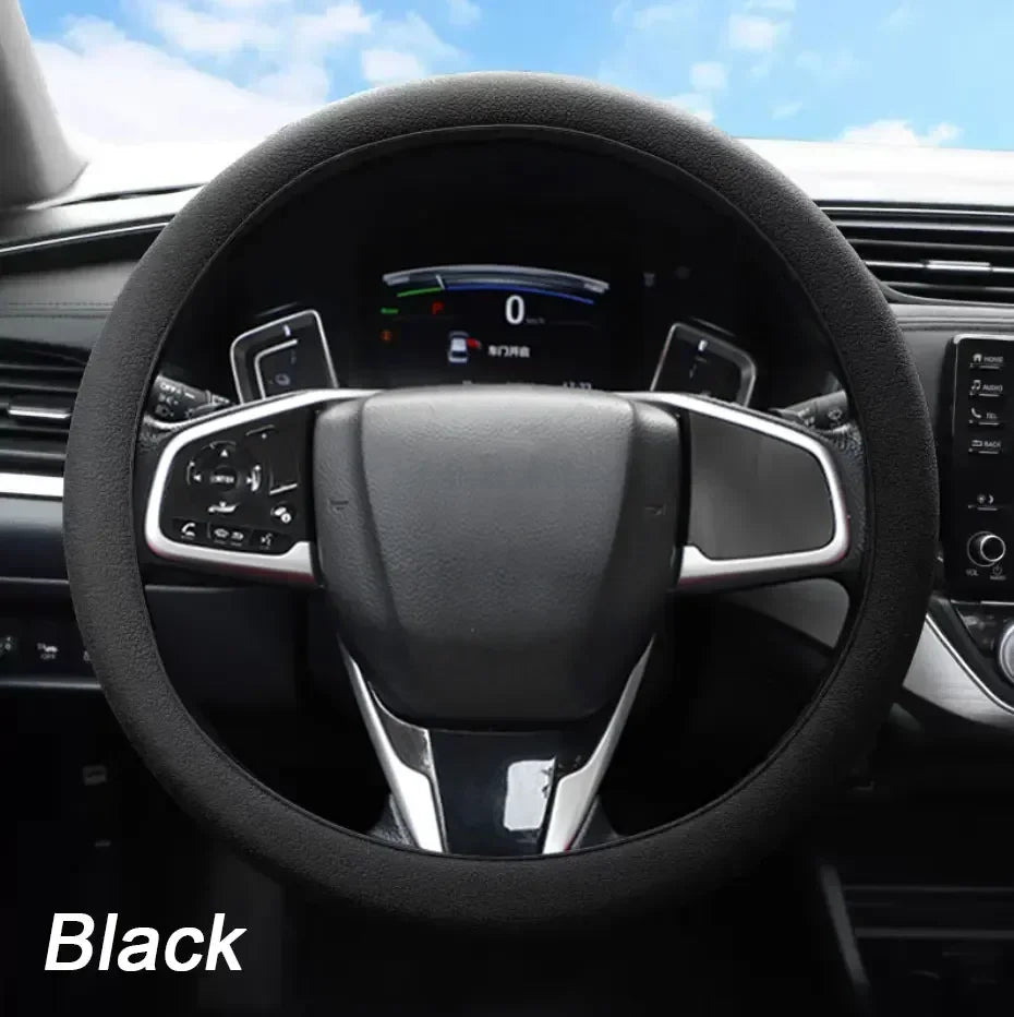 Black soft silicone steering wheel cover installed in a car interior.