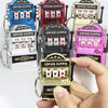 A hand holds a gold mini fruit slot machine keychain fidget toy with colorful fruit symbols.