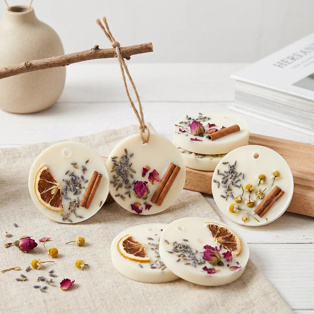 White silicone molds for hanging soap and aromatherapy discs with dried botanicals and cinnamon sticks