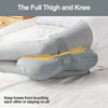 Almohada de muslo y rodilla gris sobre ropa de cama blanca.