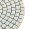 A close-up view of a set of diamond polishing pads for stone and concrete, showing various grits.